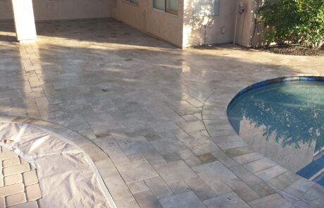 This image shows a pool deck made up of pavers that is being repaired.