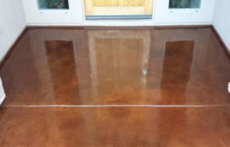 This image shows a foyer that has concrete stained floor.