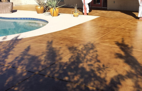 This image shows a pool deck that is concrete stained.