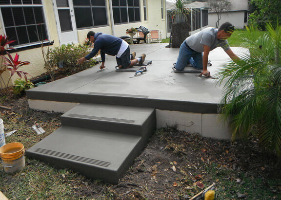 This image shows men resurfacing a patio.