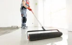 This image shows a man applying epoxy paint on the floor.