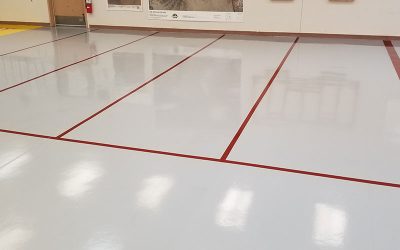 This image shows a commrcial floor with a white epoxy floor with red lines.