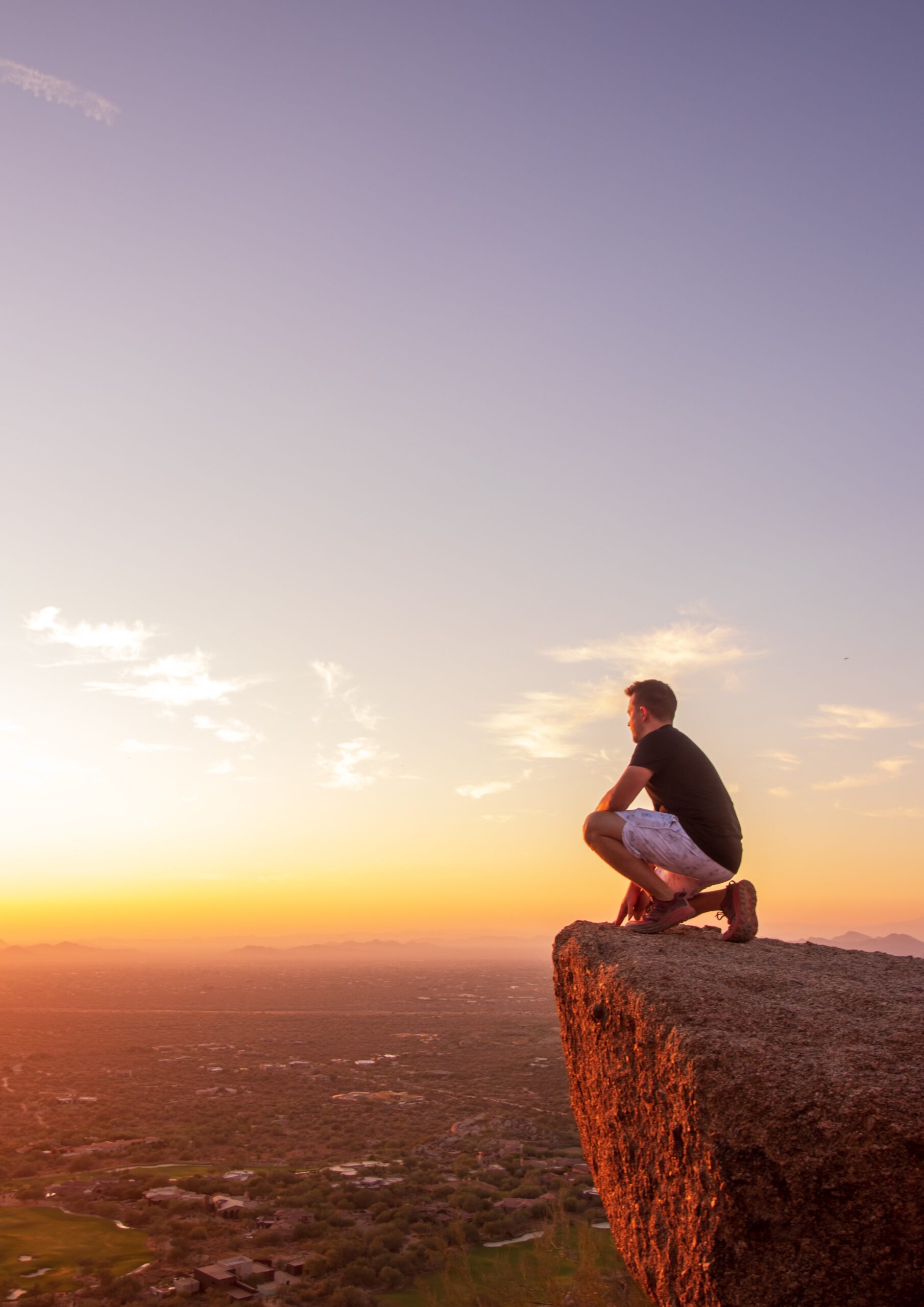 This image shows a manon a mountain overlooking North Scottsdale in Arizona.